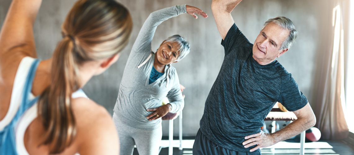 Shot of a senior man and woman working out with the help of an instructor