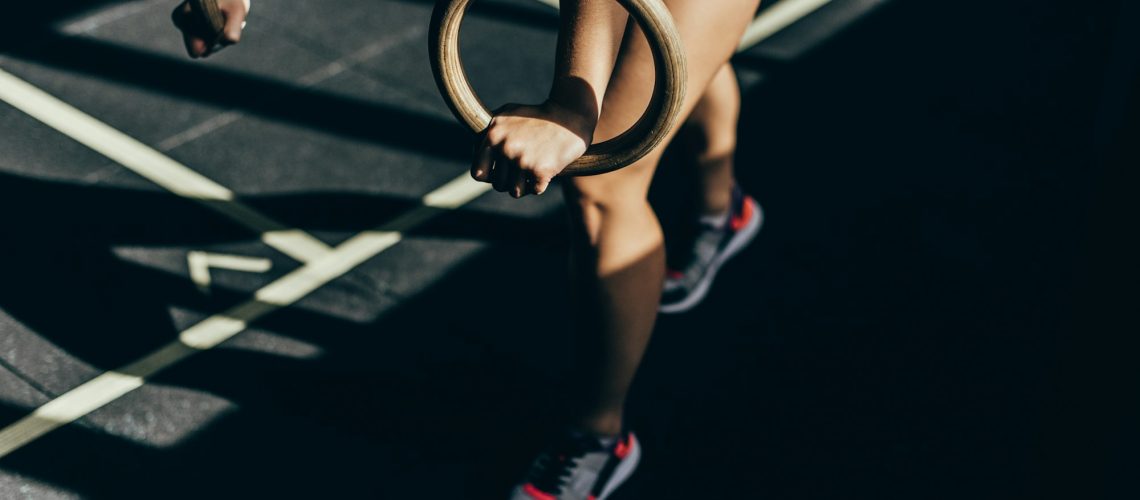 Cropped Shot Of Athletic Woman Doing Exercises With Gymnastic Rings At Gym